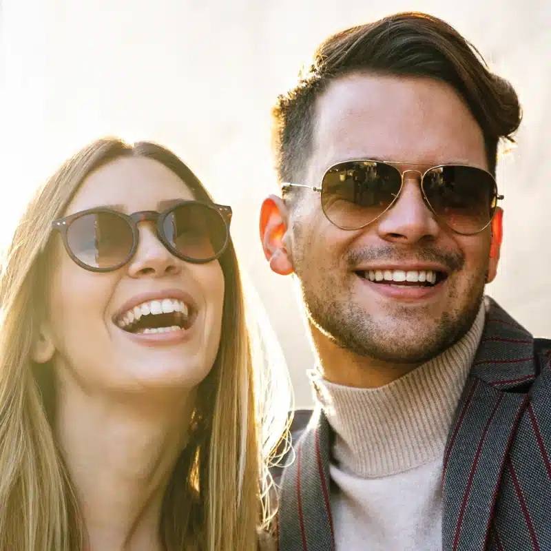 A female and male both wearing designer sunglasses.