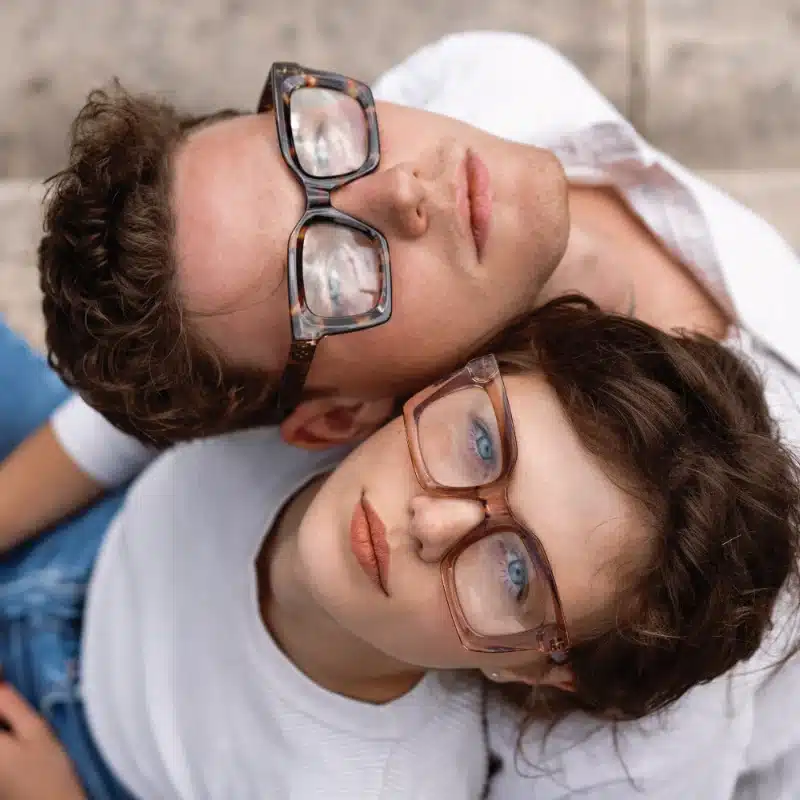 A male and female look up wearing glasses.